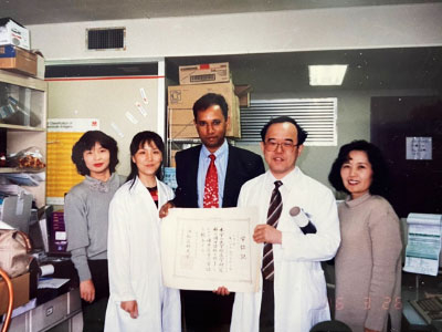 With the PhD award: me, Dr. She Liping (Junior PhD student from China), Dr. Naohiro Kanayama, other laboratory mates: 26th March 1996.1996年3月26日、博士号学位を持つ私。She Liping（中国からの博士課程学生）と金山尚裕先生と研究室の仲間と共に。